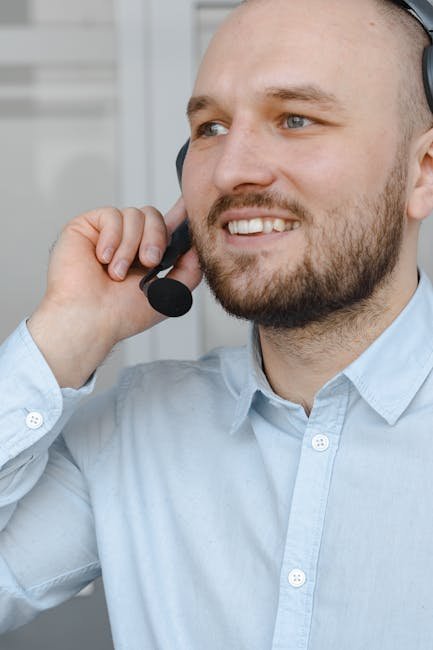 Smiling man with headset providing customer service support on a call.