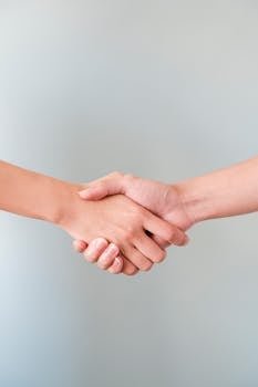 A detailed view of a handshake between two individuals, symbolizing agreement and collaboration.